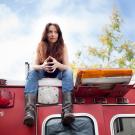 Performer Eliza Jane Schneider sits atop an old red bus